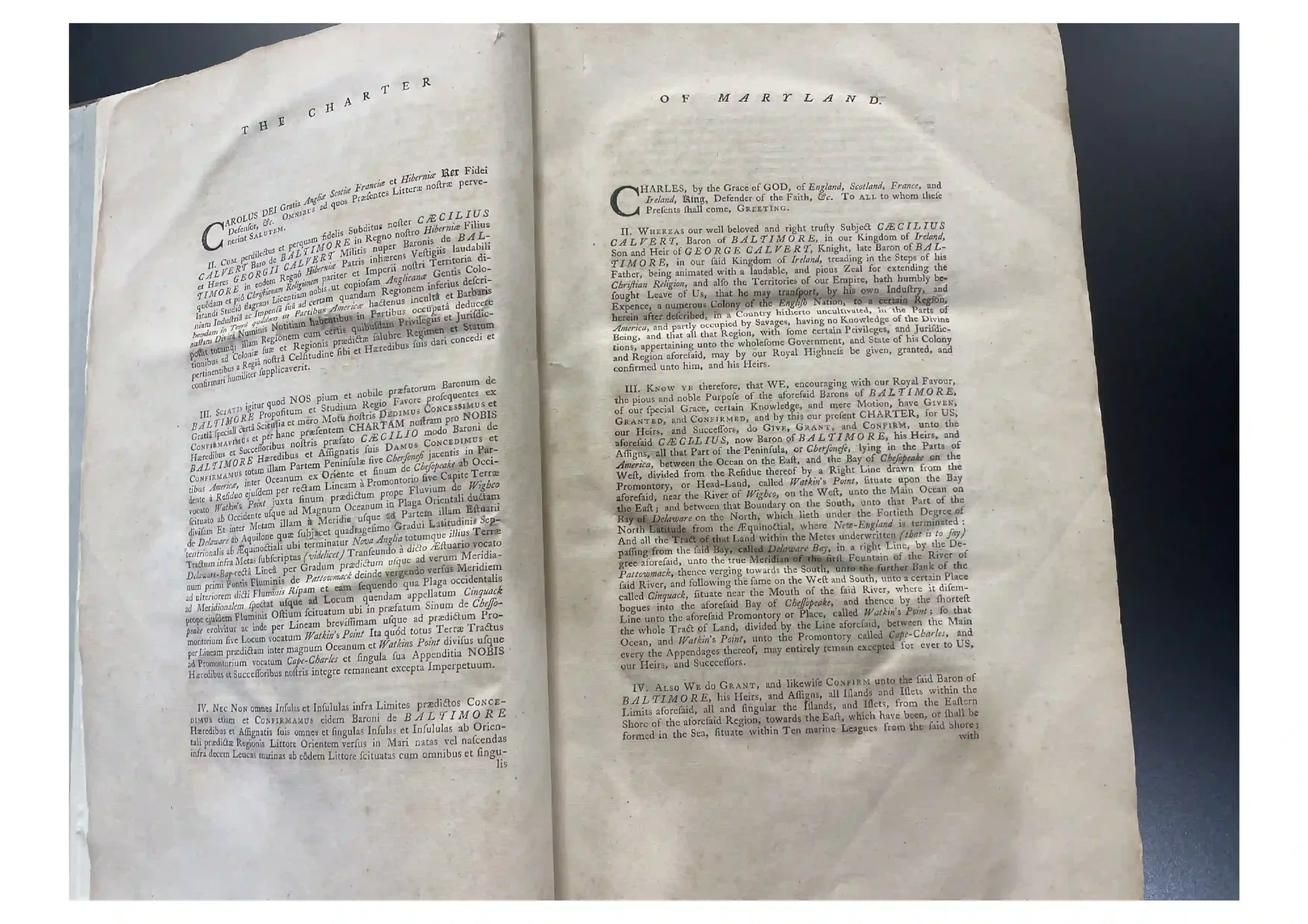 Open spread of an aged book showing two pages with the header 'The Charter of Maryland' and dense colonial-era text.